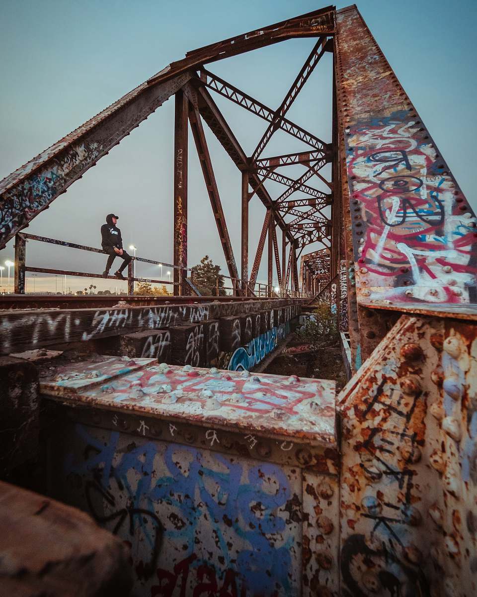 23516 magic mountain pkwy man sitting on brown metal bridge santa clarita